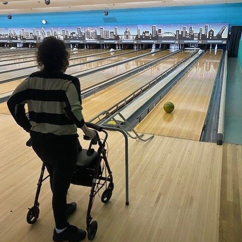 Elderly resident at a group outing at a bowling alley