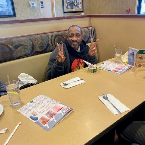 Elderly resident at a group outing in a restuarant