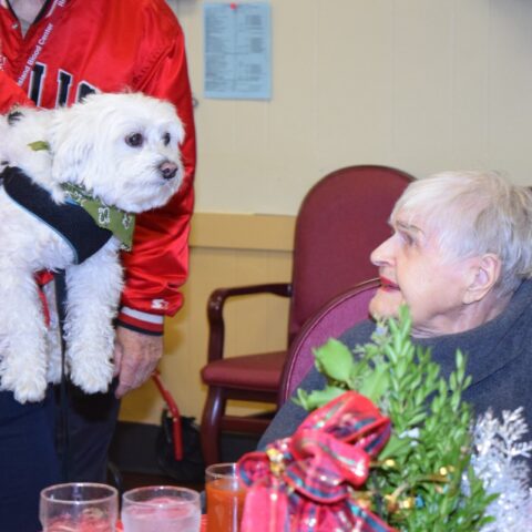 Elderly resident enjoying a visit from a dog, during the Healing Power of Pets event