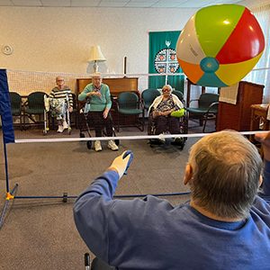 Elderly residents playing volley ball inside