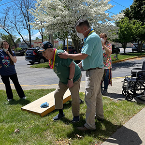 Elderly residents outside playing cornhole